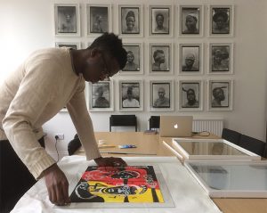 Chiadikobi Nwaubani installing 'Susu Boy' as part of the Photographic Affordances exhibition at the Royal Anthropological Institute, London.